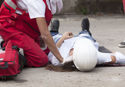 Paramedic performing cpr on person women on street