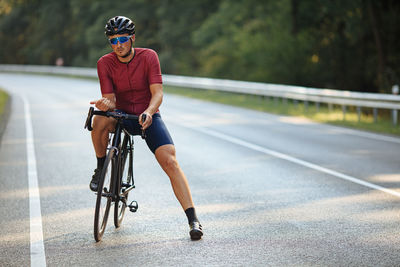 Full length of man riding bicycle on road