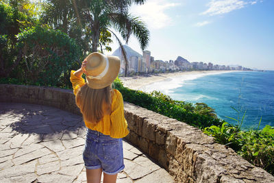 Young traveler woman in yellow shirt and hat on rio de janeiro viewpoint 