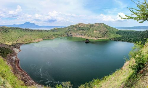 Scenic view of lake by mountains against sky