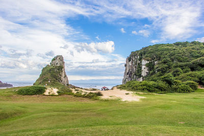 Scenic view of landscape by sea against sky