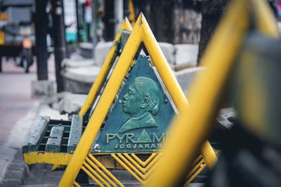 Close-up of yellow sign on street