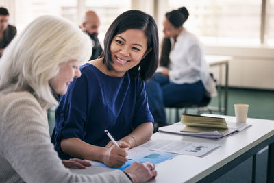 Smiling women sitting together in class