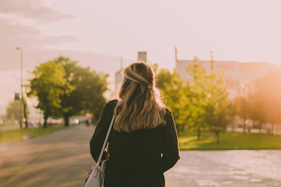 Rear view of person standing in city against sky