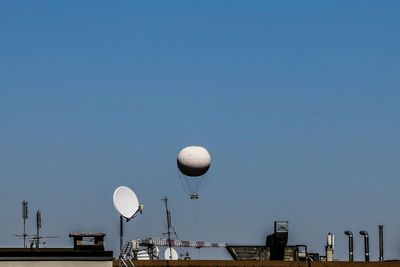 Communications tower on roof against clear sky