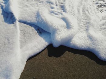 Close-up of snow on beach during winter