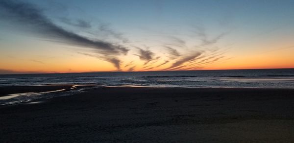 Scenic view of beach against sky during sunset