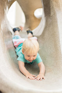 Child playing on outdoor playground. toddler plays on school or kindergarten yard. active kid on