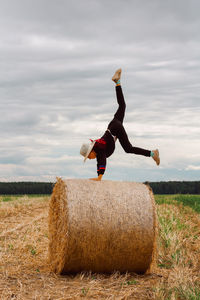 A child on a haystack does a handstand. carefree childhood in the country, summer mood