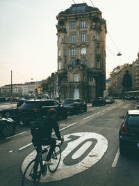 Vehicles on city street against sky