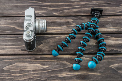 High angle view of old camera with tripod on table