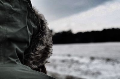 Close-up of person in hooded shirt at beach