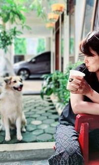 Woman with dog sitting on mobile phone