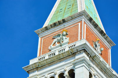 Low angle view of clock tower against blue sky