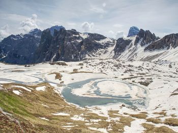 View over alpine valley to sharp alps peaks . mountains increased from cloudy background