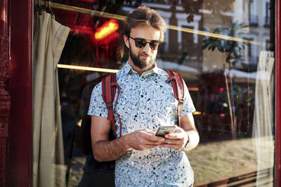 Midsection of man using mobile phone