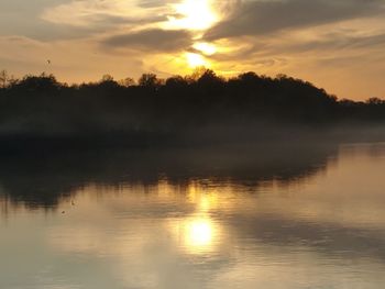 Scenic view of lake against sky during sunset