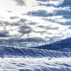 Scenic view of snow covered land against sky