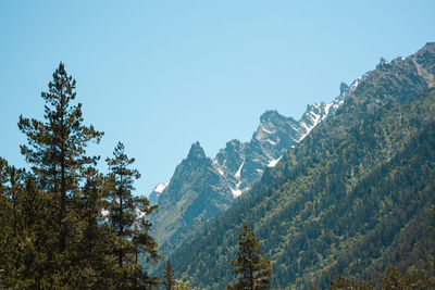 Low angle view of snowcapped mountains against clear sky