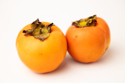 Close-up of orange fruit against white background