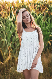 Portrait of young woman standing on field