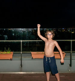 Full length of shirtless boy standing in swimming pool