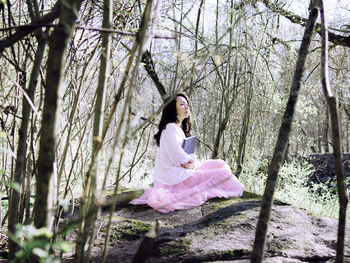 Young woman sitting on tree