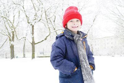 Little boy standing on snow covered landscape