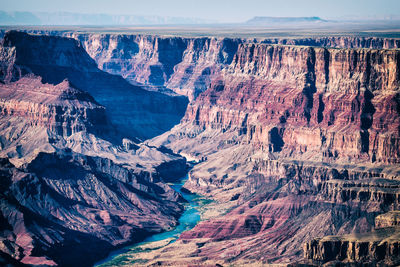 View into the grand canyon with long shadows and the blue colorado river deep down