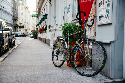 Bicycle parked on sidewalk by building