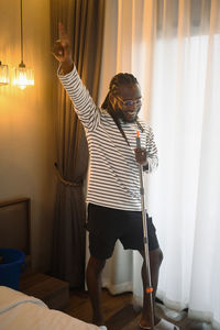 Rear view of young woman standing at home