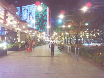 People on illuminated city at night