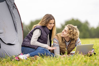 Young woman using mobile phone in grass