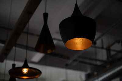 Low angle view of illuminated pendant lights hanging from ceiling