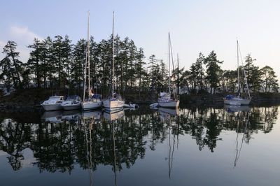 Boats moored in lake against sky