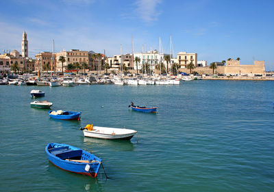 Boats moored on sea against blue sky