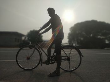 Side view of man riding bicycle on road