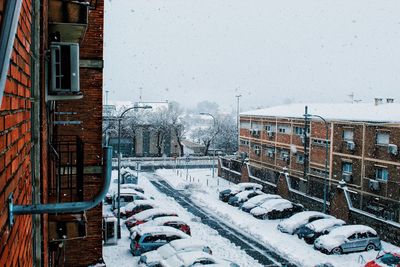 Snow covered buildings in city during winter