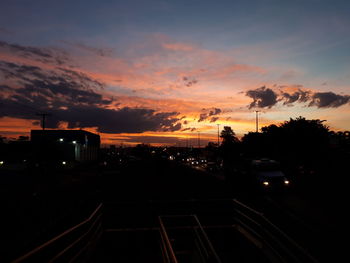 Silhouette city against sky during sunset