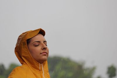 Side view of young woman with eyes closed during rainy season