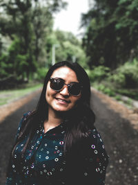 Portrait of smiling young woman standing on road