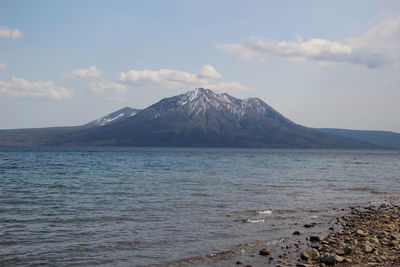 Scenic view of sea and mountains against sky