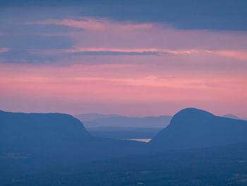 Scenic view of silhouette mountains against romantic sky at sunset