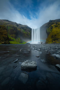 Scenic view of waterfall against sky