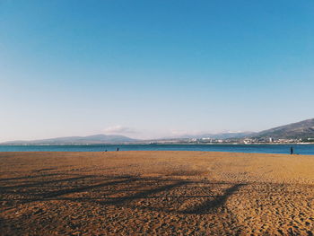 Scenic view of beach against clear blue sky