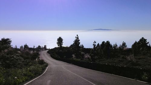 Road amidst trees against sky