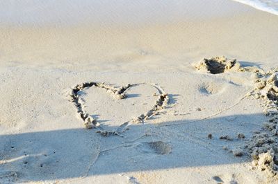 High angle view of heart shape on sand at beach