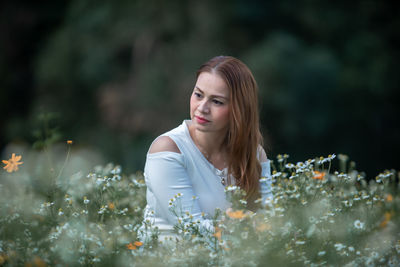 Portrait of young woman looking away outdoors