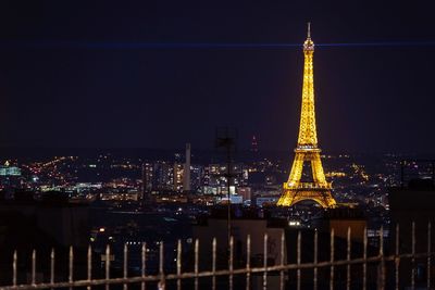 Illuminated buildings against sky at night