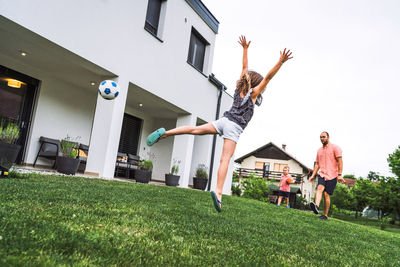 Low section of woman jumping on grassy field